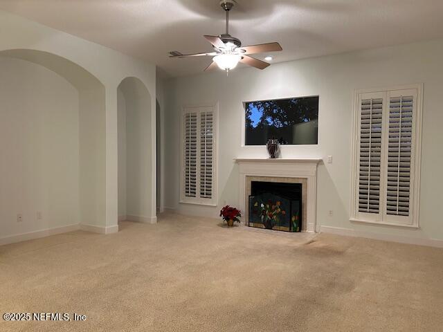 unfurnished living room featuring light colored carpet and ceiling fan