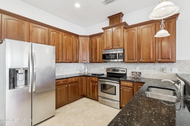 kitchen featuring sink, hanging light fixtures, light tile patterned floors, appliances with stainless steel finishes, and tasteful backsplash