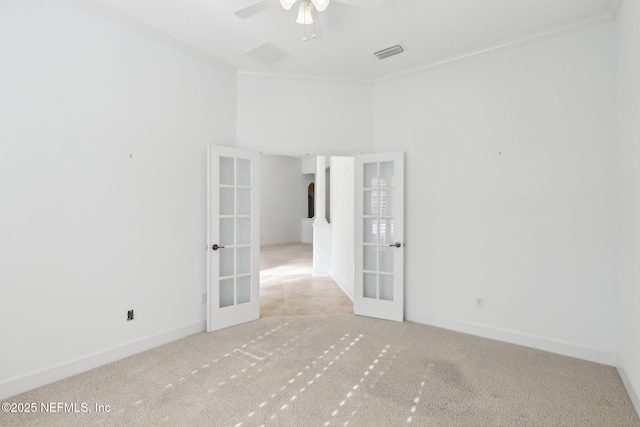 carpeted spare room with crown molding, french doors, and ceiling fan