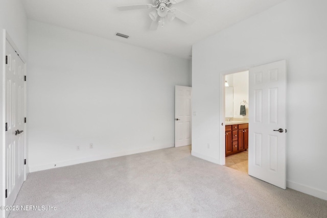 unfurnished bedroom with ensuite bathroom, ceiling fan, and light colored carpet