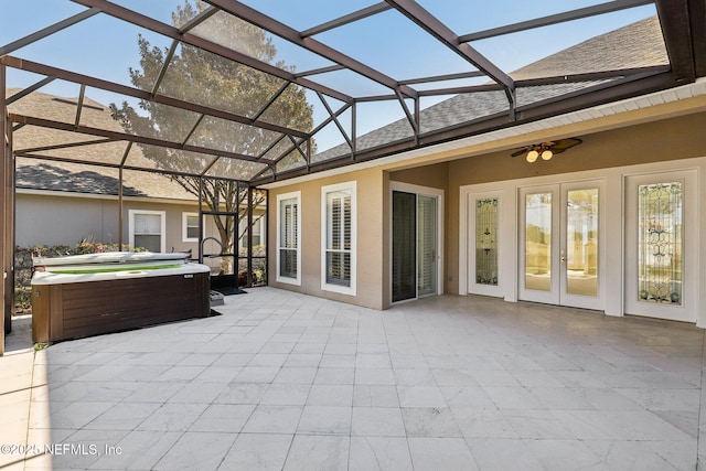 view of patio with french doors, glass enclosure, a hot tub, and ceiling fan