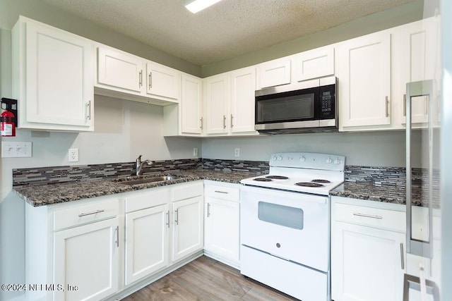 kitchen with white electric range, sink, light hardwood / wood-style flooring, a textured ceiling, and white cabinetry