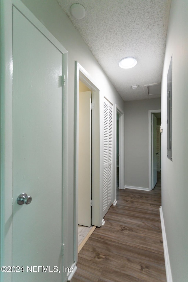 hall with a textured ceiling and hardwood / wood-style flooring