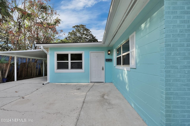 property entrance featuring a patio area and a carport