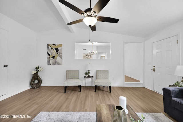 sitting room featuring ceiling fan with notable chandelier, hardwood / wood-style flooring, and vaulted ceiling