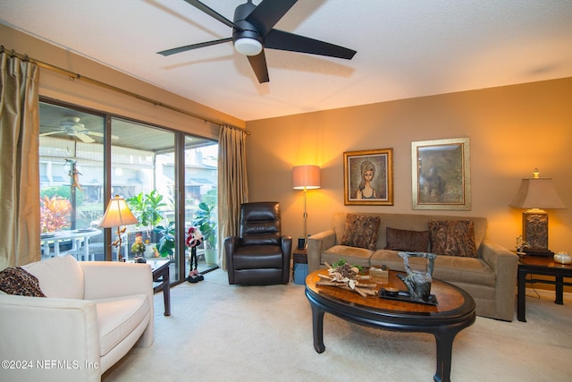 living room with light carpet, ceiling fan, and a textured ceiling