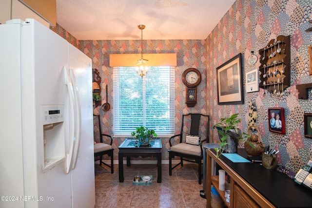 living area featuring light tile patterned floors, a textured ceiling, and a notable chandelier