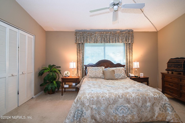 carpeted bedroom featuring a textured ceiling, a closet, ceiling fan, and lofted ceiling