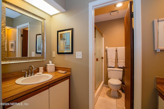 bathroom with toilet, tile patterned flooring, vanity, and walk in shower