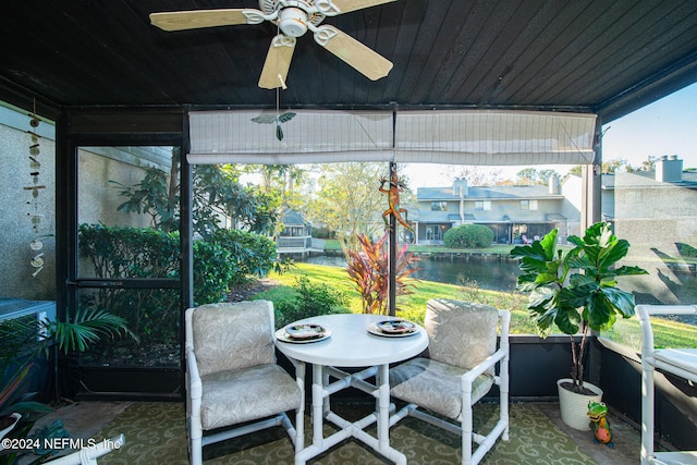 sunroom with ceiling fan, a water view, and wood ceiling