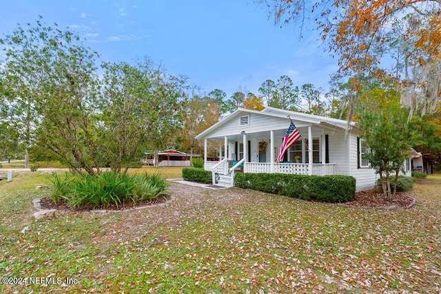 view of front of home with covered porch and a front lawn