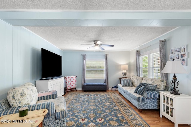 living room with dark hardwood / wood-style floors, ceiling fan, ornamental molding, and a textured ceiling