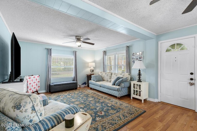 living room featuring hardwood / wood-style flooring, a healthy amount of sunlight, and crown molding