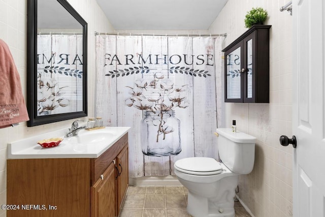 bathroom with tile patterned flooring, vanity, tile walls, and toilet