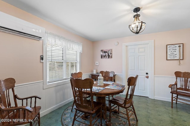 dining space with an AC wall unit and a notable chandelier