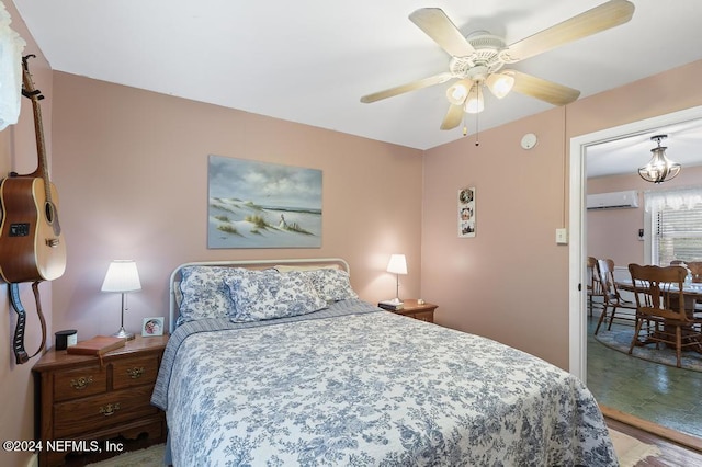 bedroom with hardwood / wood-style floors, ceiling fan, and an AC wall unit