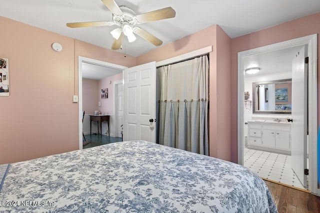 bedroom featuring dark hardwood / wood-style flooring, ceiling fan, and connected bathroom