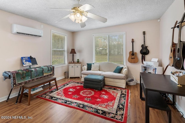 living room featuring hardwood / wood-style floors, ceiling fan, a textured ceiling, and a wall unit AC