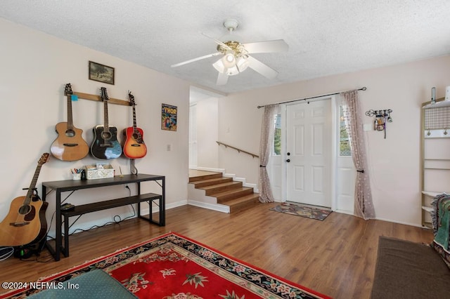 foyer entrance with ceiling fan, wood-type flooring, and a textured ceiling