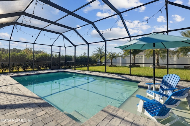 view of swimming pool featuring a patio area, a lanai, and a yard