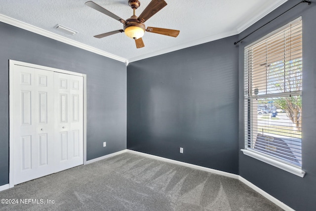 unfurnished bedroom with ceiling fan, a closet, a textured ceiling, and ornamental molding