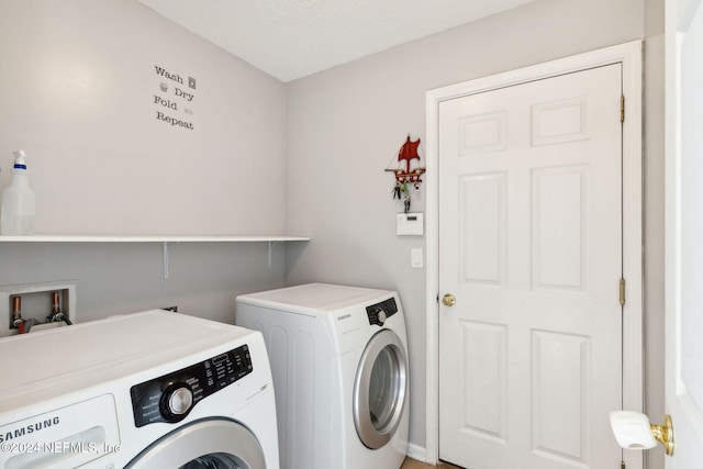 washroom with a textured ceiling and washing machine and dryer