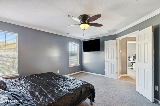 bedroom with carpet flooring, a textured ceiling, ceiling fan, and crown molding