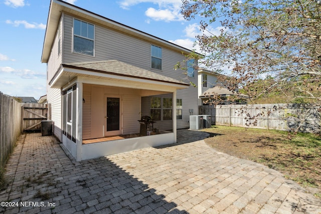 rear view of house featuring central AC unit and a patio