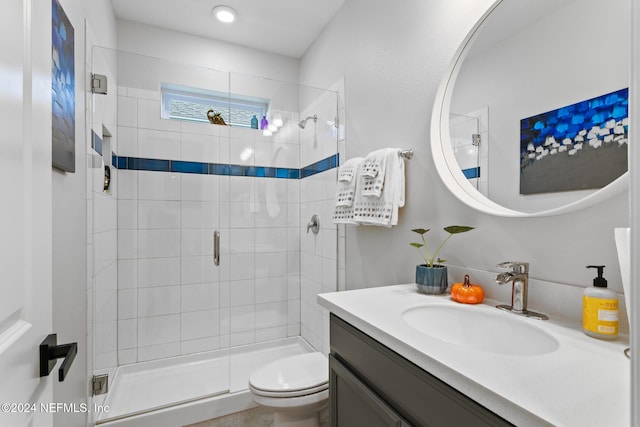 bathroom featuring vanity, toilet, and a shower with shower door