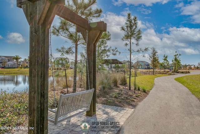 view of community with a yard and a water view