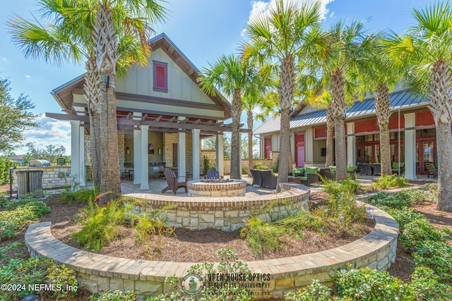 view of property's community featuring a patio area and an outdoor fire pit