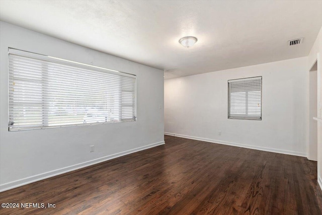 empty room with dark hardwood / wood-style flooring