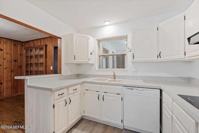 kitchen with dishwasher, wood walls, sink, light wood-type flooring, and white cabinetry