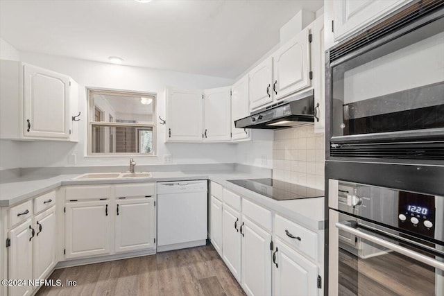 kitchen featuring white cabinetry, sink, backsplash, black appliances, and light wood-type flooring