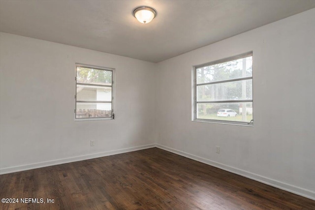 spare room with a wealth of natural light and dark hardwood / wood-style floors