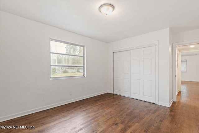 unfurnished bedroom featuring dark hardwood / wood-style floors and a closet