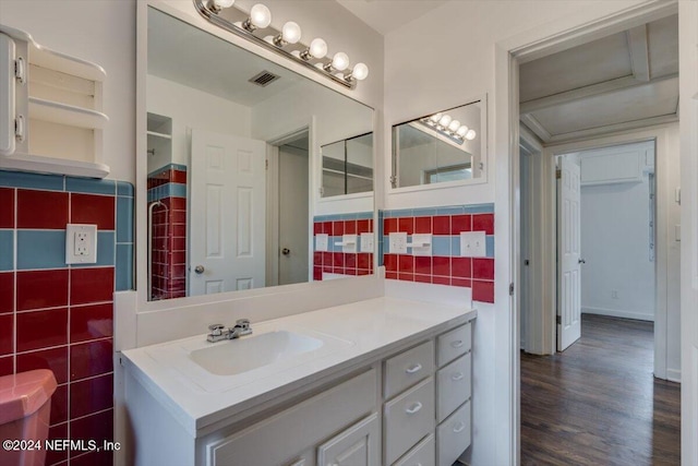 bathroom with tasteful backsplash, vanity, tile walls, and hardwood / wood-style flooring