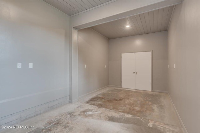 unfurnished room with wooden ceiling, ornamental molding, and concrete floors