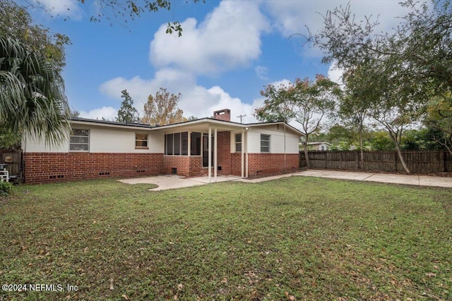 back of house with a yard and a patio