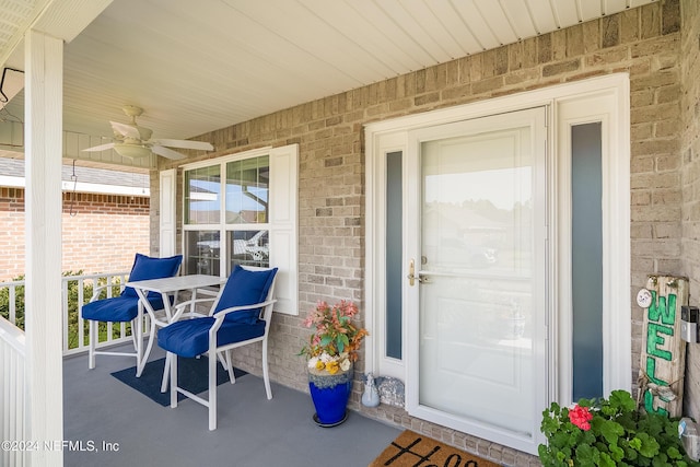 view of exterior entry with a porch and ceiling fan