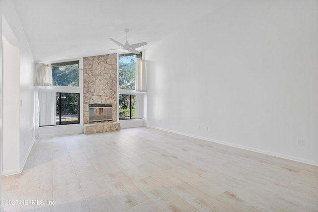 unfurnished living room with ceiling fan, a fireplace, high vaulted ceiling, and light hardwood / wood-style floors