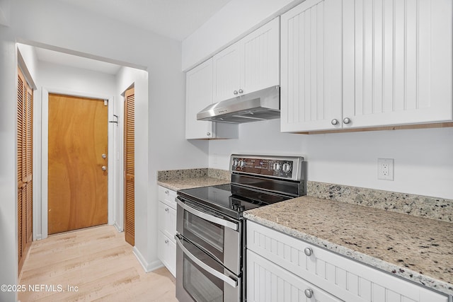 kitchen with electric range, white cabinetry, light stone countertops, and light hardwood / wood-style floors