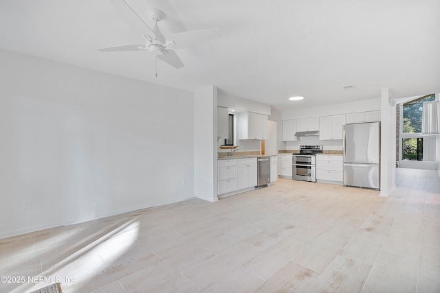 kitchen featuring ceiling fan, sink, white cabinetry, and stainless steel appliances