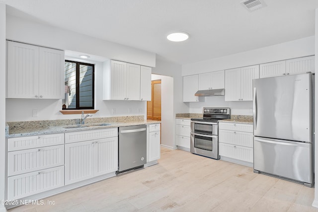 kitchen with light stone countertops, sink, white cabinets, and stainless steel appliances