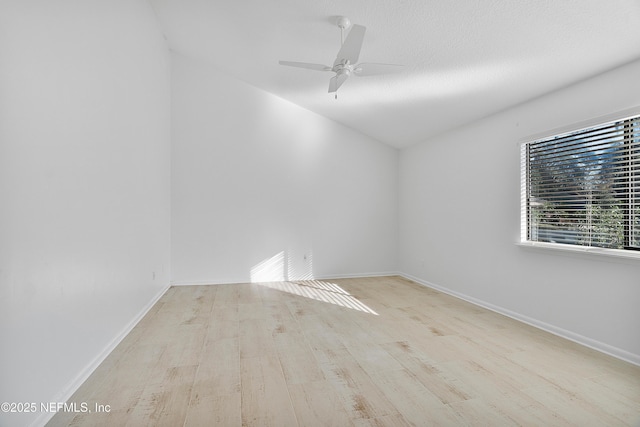 spare room featuring vaulted ceiling, ceiling fan, light hardwood / wood-style flooring, and a textured ceiling