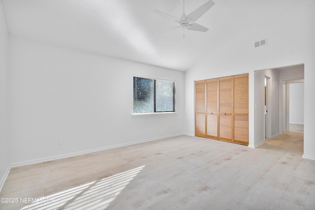 unfurnished bedroom with light wood-type flooring, a textured ceiling, ceiling fan, high vaulted ceiling, and a closet