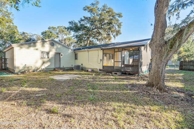 rear view of house featuring a sunroom and central AC unit