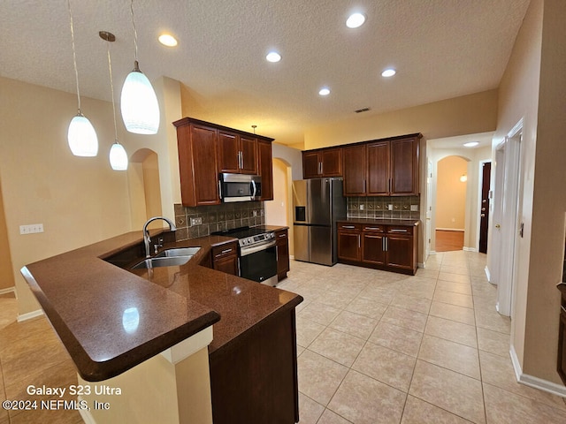 kitchen with tasteful backsplash, kitchen peninsula, sink, and appliances with stainless steel finishes