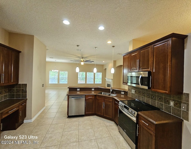 kitchen with sink, ceiling fan, tasteful backsplash, kitchen peninsula, and stainless steel appliances