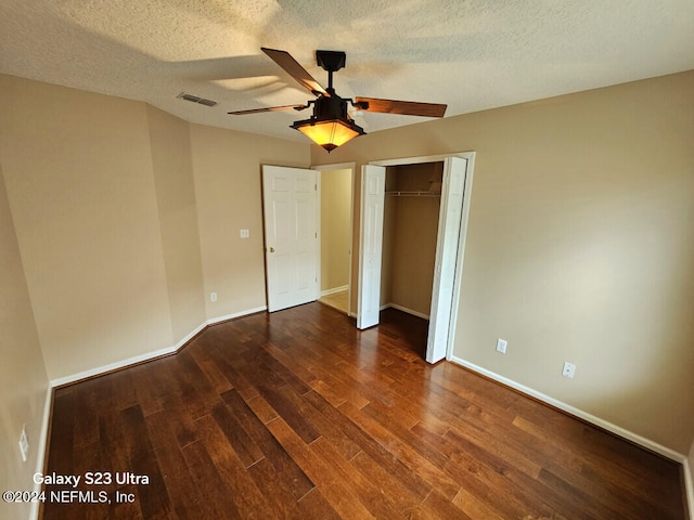 unfurnished bedroom featuring a closet, ceiling fan, dark hardwood / wood-style flooring, and a textured ceiling